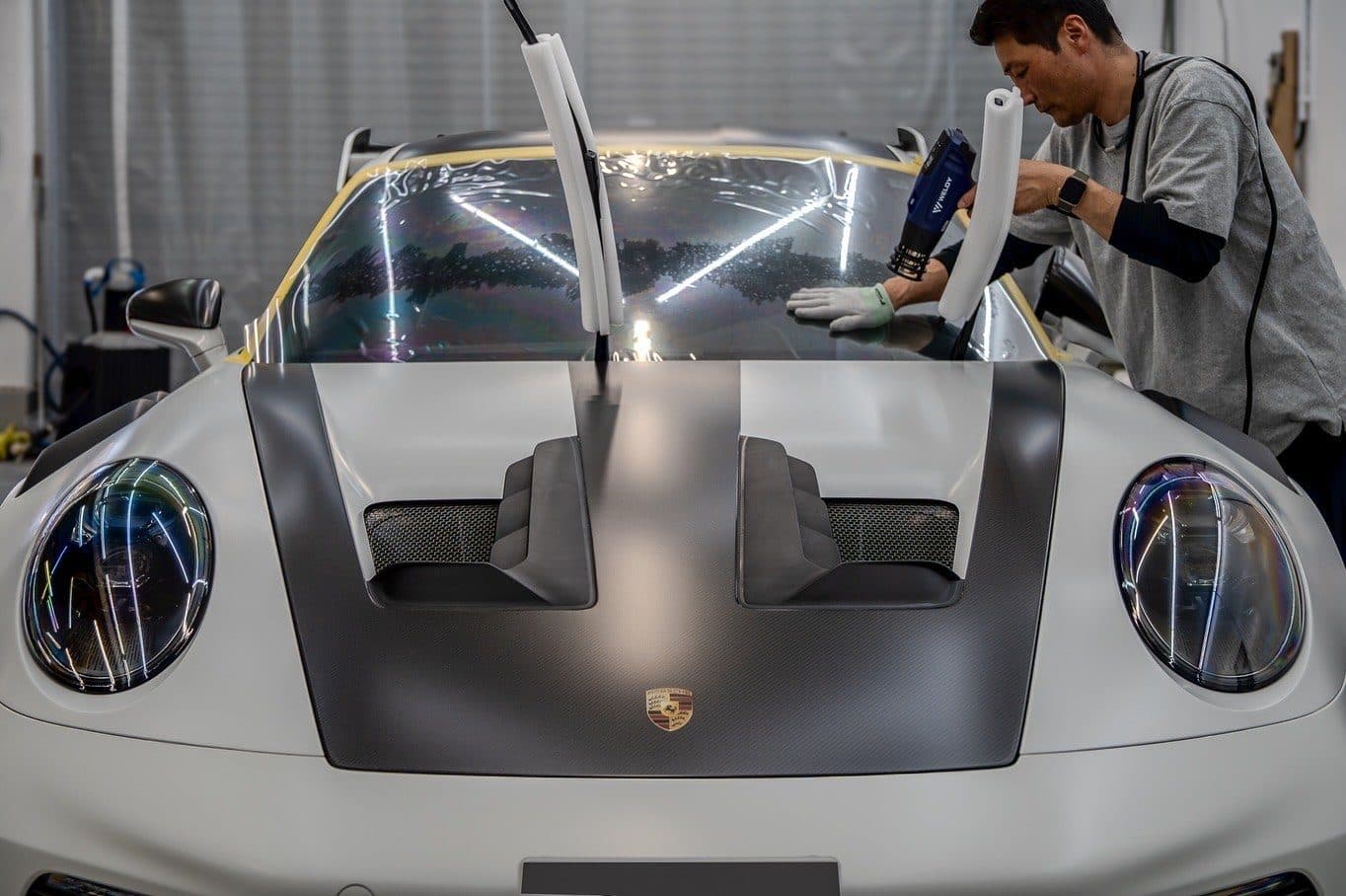 ポルシェ 911 にプロテクションフィルムを施工しているところ。ホコリを断った環境で、一枚ずつ|福井市 アニマートカーメンテナンス