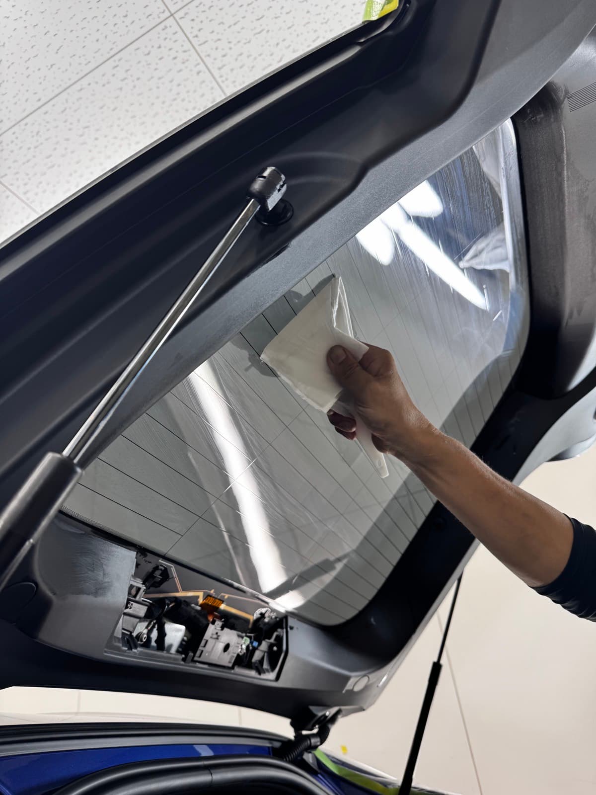 内装を養生して、車内からフロントガラスにフィルムを貼っているところ|福井市 アニマートカーメンテナンス
