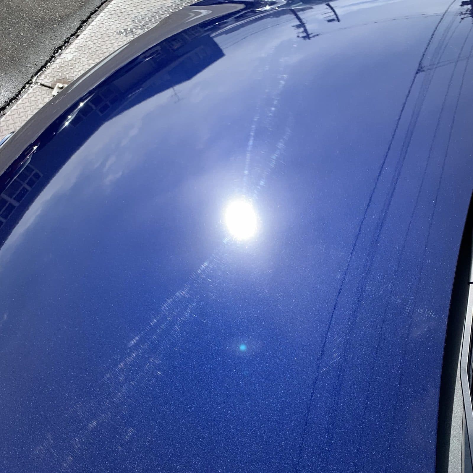 太陽光の下で、埋めた物が剥がれてバフ目(オーロラ)が出た青い塗装|カーコーティング・研磨 福井市 アニマートカーメンテナンス